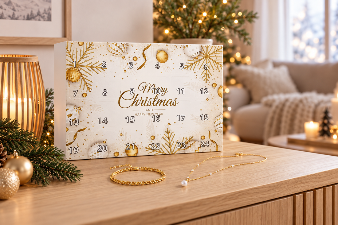 Adventskalender für Erwachsene in Weiss und Gold auf Holztisch, davor Armbänder, im Hintergrund ein Weihnachtsbaum