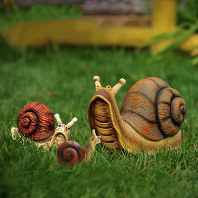 Drei Schnecken als Gartenfigur in Klein, Mittel und Gross im grünen Rasen, Kunstharz mit roten und braunen Häusern