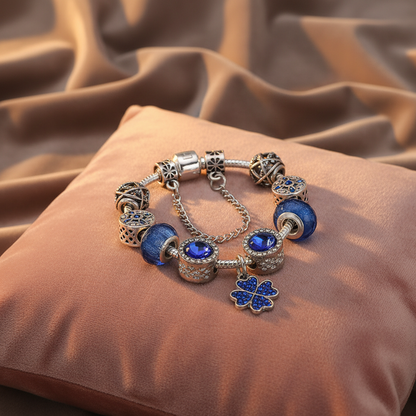 Nahaufnahme des Kristall Charm Armbands in Blau, zeigt die tiefblauen Murano-Glasperlen und den vierblättrigen Kleeblatt Anhänger.
