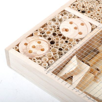 Nahaufnahme der Bambusröhren und Holzscheiben mit Bohrlöchern im Bienenhotel aus Naturholz