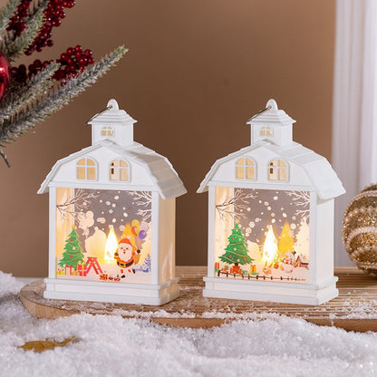 Zwei weisse Weihnachtslaternen mit Weihnachtsmann und Tannenbaum auf Kunstschnee