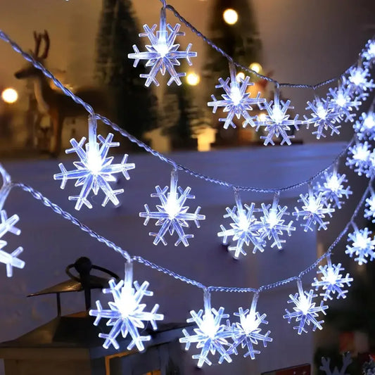 Kaltweisse LED Schneeflocken Lichterkette über einem Kaminsims mit Winterdeko