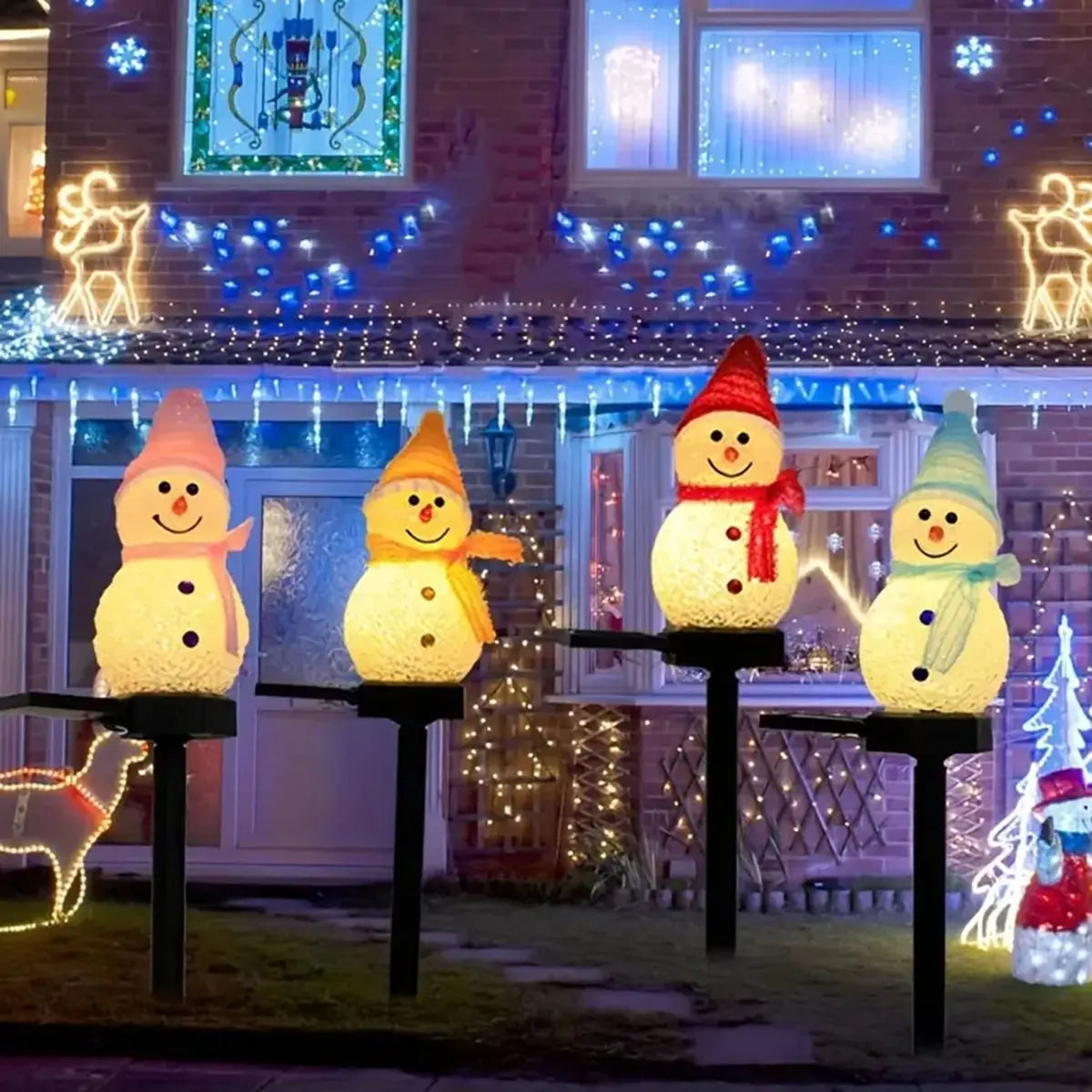 Vier Schneemänner beleuchtet für aussen vor einem weihnachtlich beleuchteten Haus