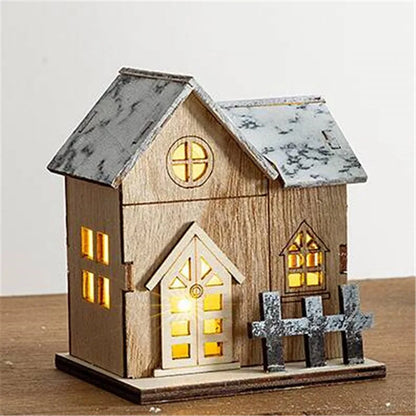 Beleuchtetes Holzhaus mit zwei Giebeln, warmweisse Fenster und grauer Zaun