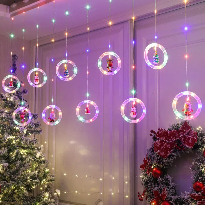 Bunte Ringe mit Figuren am Fenster neben Christbaum und rotem Kranz