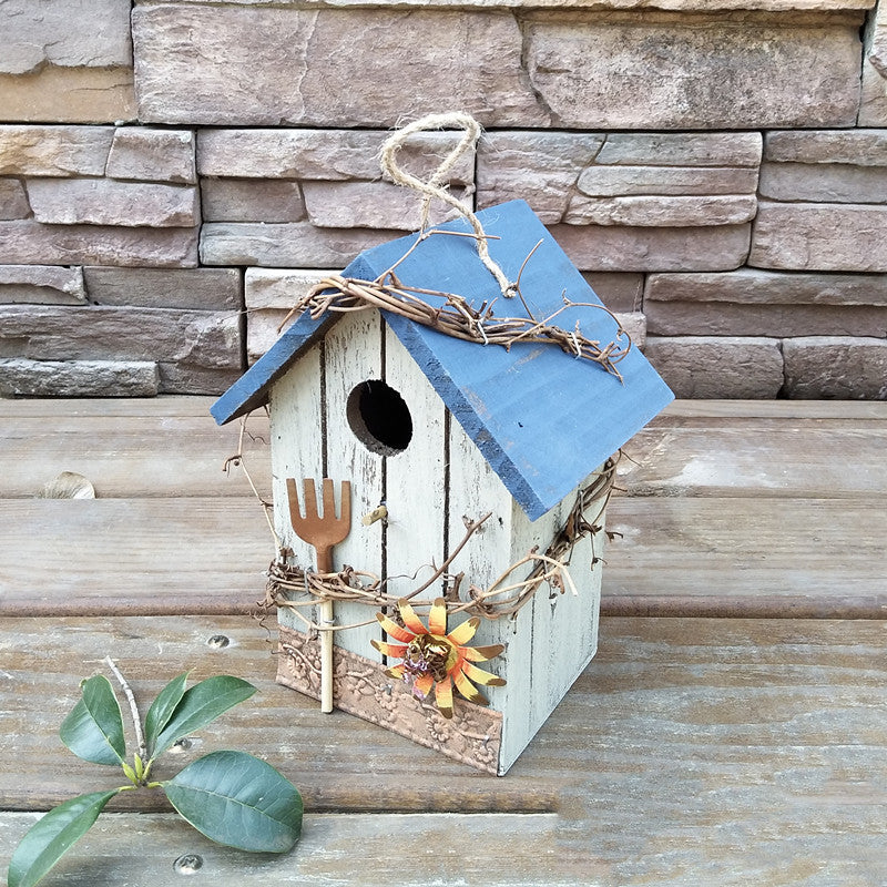 Nistkasten im Chalet-Stil mit blauem Dach, Sonnenblume und Gartengabel aus Holz zum Hängen