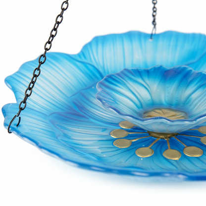 Detailansicht der blauen Glasschale mit goldenem Blütenmuster in der Mitte der Vogeltränke