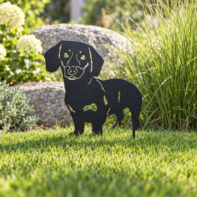 Hund Gartenstecker Dackel als schwarze Metall-Silhouette im Rasen vor einem Stein, wetterfeste Gartendeko