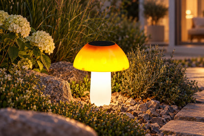 Solar Pilzleuchte mit warmem Licht im Garten zwischen Steinen und Pflanzen