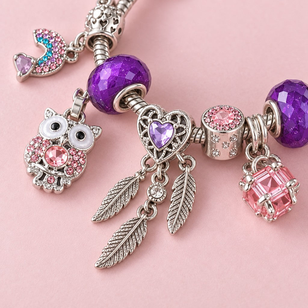 Nahaufnahme: violette Glitzerperlen, Eule mit rosa Strass, Traumfänger-Herz mit Federn und rosa Würfel